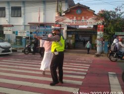 Peduli Keselamatan, Polisi Bantu Sebrangkan Anak Sekolah